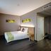 Best Western Hotel Brussels South guest room in Ruisbroek with a single bed, bedside table, and window curtains