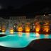 Gazelle Resort & Spa in Karacasu with lit outdoor pool beside a stone hotel facade at night