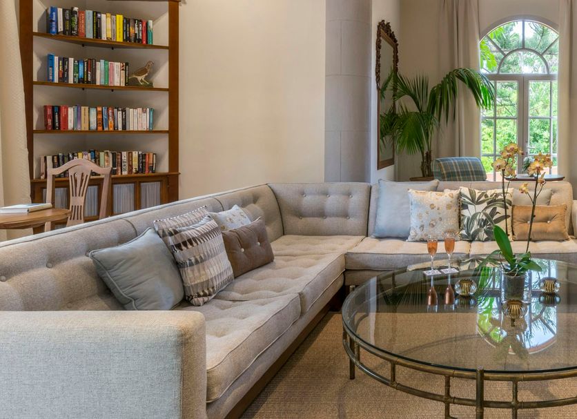 Bahia Del Duque in Adeje: elegant lounge with sectional sofa, armchairs, round glass table and tall palms
