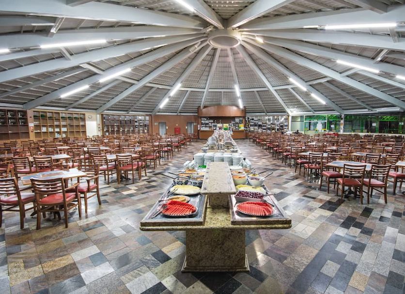 Hotel Vilage Inn Poços de Caldas buffet dining hall with tables under a circular ceiling