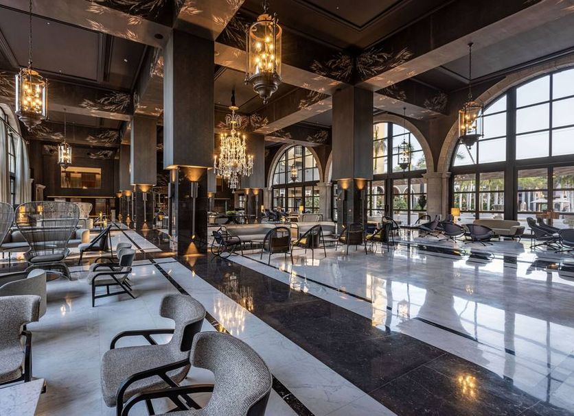Lopesan Costa Meloneras Resort & Spa lobby with chandeliers, arched windows and glossy marble floors