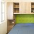 Del Garda Village and Camping in Peschiera del Garda: compact bedroom with built-in wood storage and green headboard