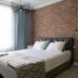 Luna Boutique Hotel in Antalya guest room with brick accent wall, bed, vanity, and sheer curtains