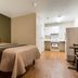 HomeTowne Studios by Red Roof Denver - Lakewood West room with bed, kitchenette and wood floors in Lakewood