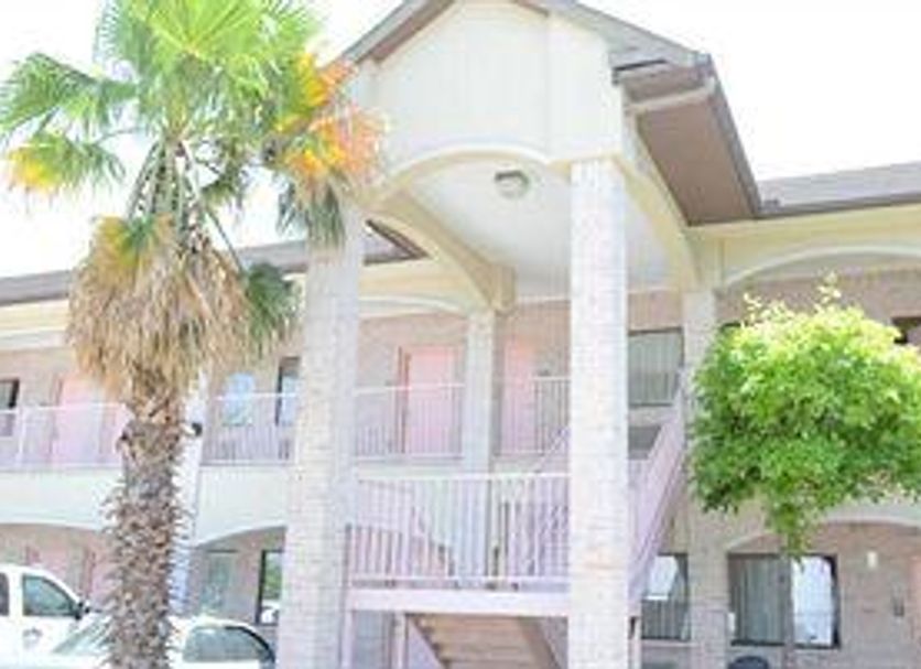 Texan Inn & Suites Houston exterior with palm trees and two-story motel-style balconies
