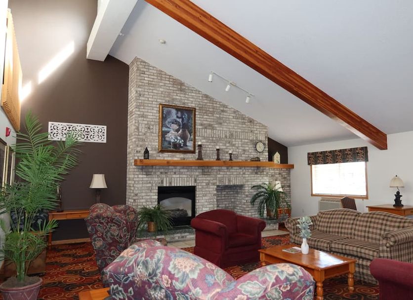 Americas Best Value Inn Annandale lounge with stone fireplace, plaid sofa and vaulted ceiling