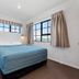 Knightsbridge Court Motor Lodge Blenheim guest room with a bed, two windows and curtains