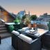 Petit Hôtel Confidentiel in Chambéry rooftop terrace with seating, plants, and city views at dusk