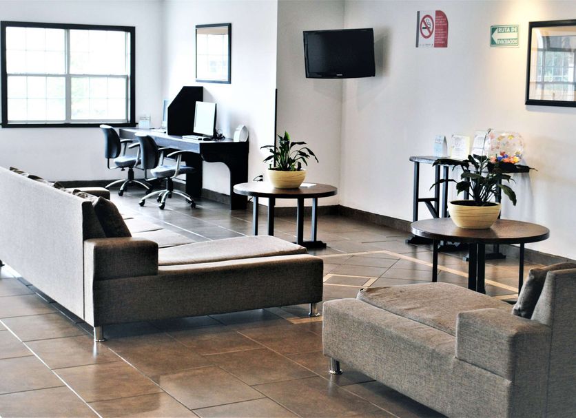 Microtel Inn & Suites by Wyndham Toluca lobby with seating area, desks and wall-mounted TV
