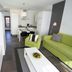 Club del Carmen in Tías: modern apartment living area with lime-green sofa and kitchenette