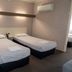 Tumut Valley Motel Tumut room with two single beds, brick accent wall and wall-mounted air conditioner