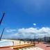 Hostel Dos Gringos in Maricá with oceanfront boardwalk, sandy beach, and clear blue sky