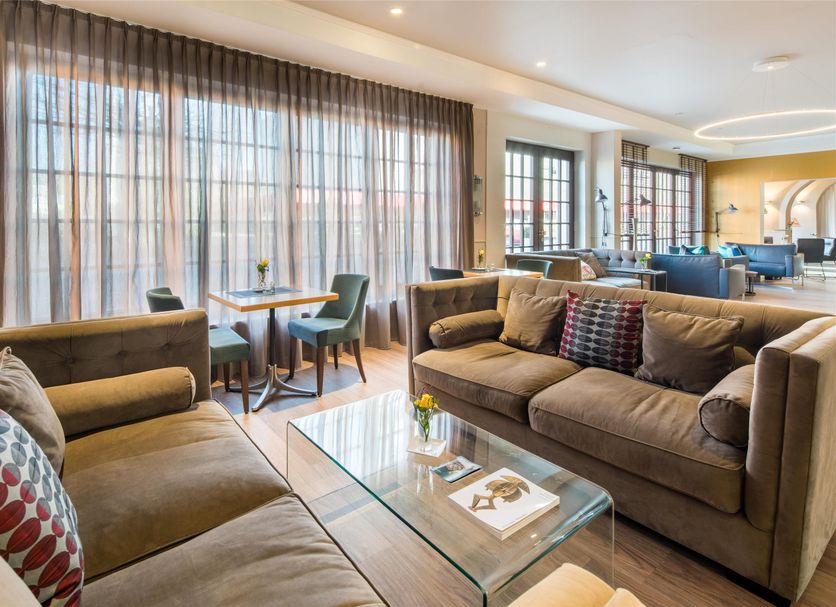 Best Western Hotel Würzburg Sued lounge with sofas, glass coffee table and small dining area in Wurzburg