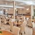 Mavrikos Hotel in Tsilivi dining room with round tables, cream chairs, and bright buffet area