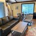 Bramblebank Cottages in Harrison Hot Springs living room with sofa, armchair, table, and stairs