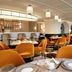 Grand Josun Busan restaurant with orange chairs, set tables and arched windows in Busan