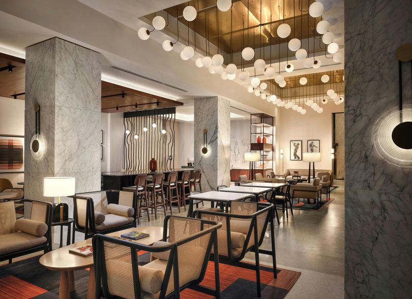 Canopy by Hilton New Orleans - Downtown lobby with marble columns, pendant lights, and lounge seating