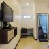 Luna Capsule in Semporna room with wall TV, desk, and bathroom doorway