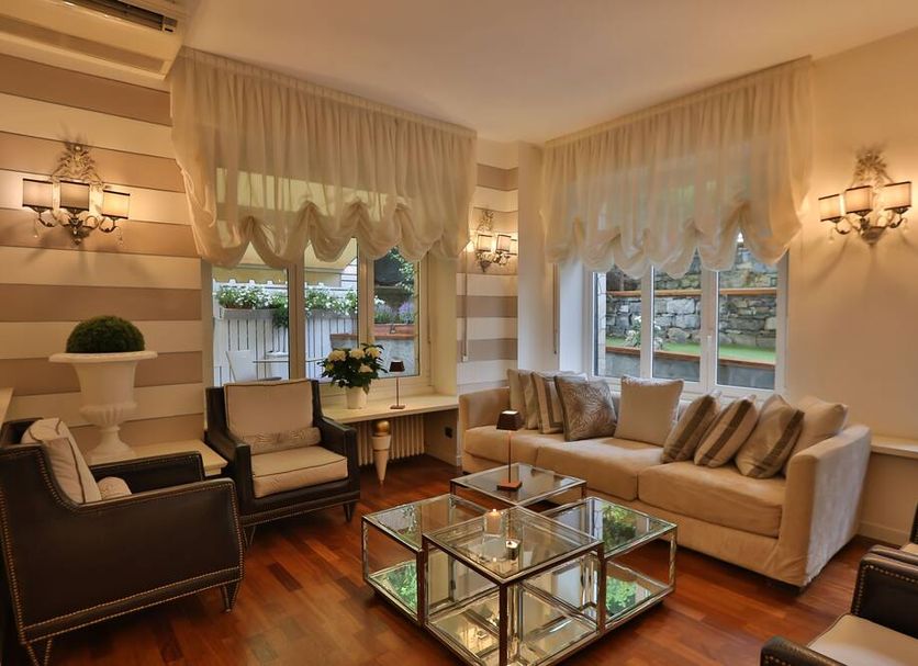 Hotel Tigullio Et De Milan lounge in Santa Margherita Ligure with striped walls, sofas, and glass coffee table