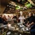 Hotel Colvenier in Antwerp wine cellar restaurant with guests dining beneath a ceiling of wine bottles