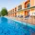 The Breath Khao Yai in Mu Si, outdoor pool beside orange hotel building with loungers and mountain view