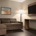 La Quinta Inn & Suites by Wyndham Montgomery room with sectional sofa, floor lamp and wall-mounted TV