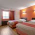 Motel 6 El Paso - Southeast guest room with two double beds and orange accent wall in El Paso