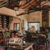 Posada Puerto Bemberg in Puerto Libertad: rustic lounge with high wood-beam ceiling, fireplace and seating.