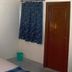 Hotel Casa di William in Khajurāho room with bed, blue curtain and wooden wardrobe