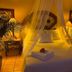 The Mexican Inn in Cabo San Lucas, cozy bedroom with canopy bed, warm lighting and potted palms