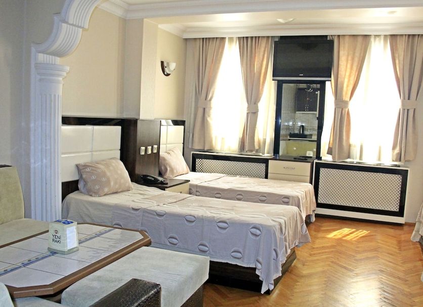 Konak Apart Hotel Istanbul room with twin beds, parquet floor and tall curtained windows