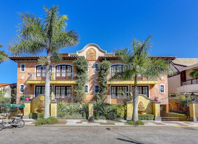 Villas Jurerê Hotel Boutique in Florianopolis with palm trees and a sunlit boutique facade