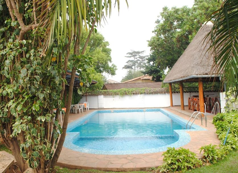Kiriri Residence Hotel in Bujumbura with an outdoor swimming pool and thatched poolside seating