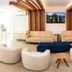 Hotel Santorini in Vila Velha lounge with beige sofas, round chairs and wall-mounted TV