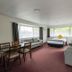 Marton Motel Nz room in Marton with sofa, dining table, and bed by windows
