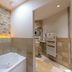 Abbaye De Maizieres, Beaune: spa-style bathroom with built-in tub, stone wall, and heated towel rail