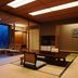 Nishimuraya Hotel Shogetsutei in Toyooka, tatami room with low table and chairs beside a forest view