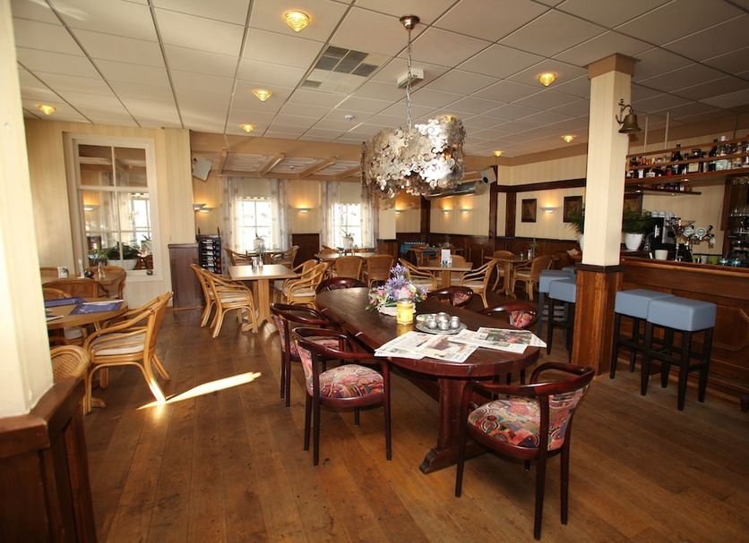 Het Wapen Van Enkhuizen restaurant with tables, chairs, and a bar in Enkhuizen