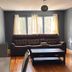 Nwk 457 Room 111-A in Newark: living area with sofa, coffee table, tall mirror, and window light