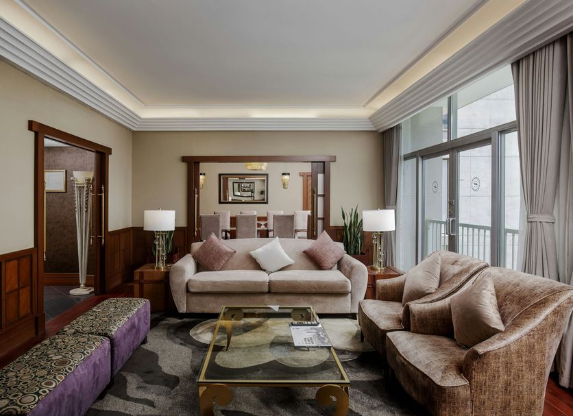 Sheraton Kampala Hotel in Kampala living room with sofa, armchairs, glass coffee table and city balcony view