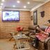 Hotel Shreesu Kathmandu lounge with leather sofa, wall art, TV, and a guest reading