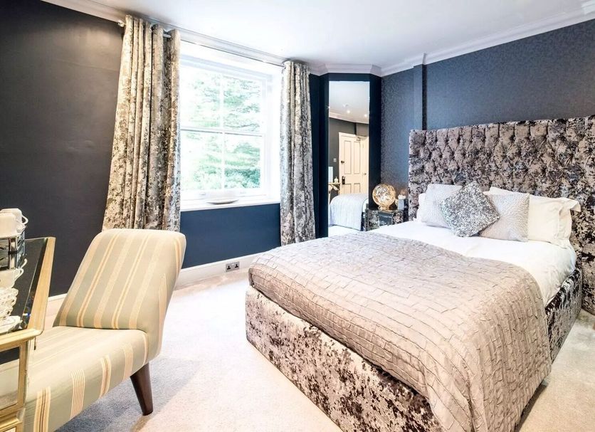 Derby Manor, Bournemouth: elegant guest room with patterned bed, mirrored bedside tables and window