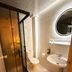 Hotel Guleryuz Antalya bathroom with glass shower, toilet, sink and round mirror
