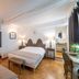 Logis - Hotel De La Mairie in Embrun: bright twin bedroom with parquet floor and antique headboard