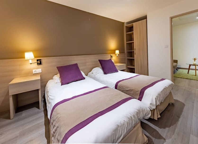 Hôtel Princes de Catalogne, Collioure: twin beds with purple accents in a guest room with bedside lamps.