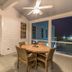 Covered porch at The Beaufort Inn in Beaufort with dining table, chairs, ceiling fan and night view