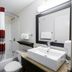 Red Roof Inn Raleigh Southwest - Cary bathroom with tub-shower, sink, toilet, and mirror in Cary