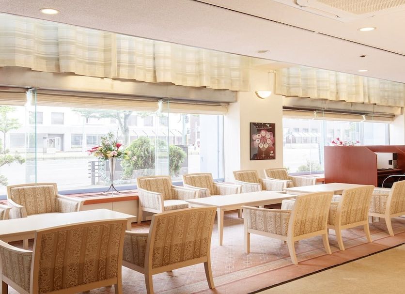 Hotel Pearl City Akita Kanto-Odori lounge with wicker chairs and large street-facing windows in Akita