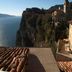 Hotel Miralago in Tremosine with cliffside lake view and tiled rooftops under a clear sky