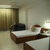 Hotel Amar Vilas in Indore guest room with two single beds, curtains, TV, and seating area